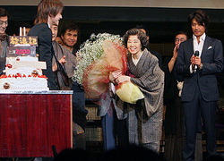 News pic of Tackey gving flowers to Mori Mitsuko